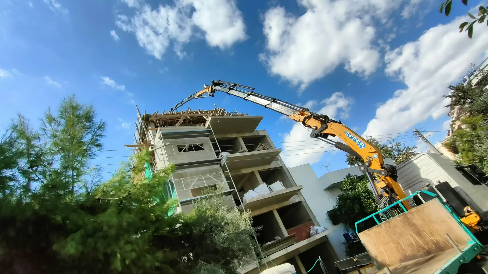 Αρθρωτός γερανός πάνω από κτίριο υπό κατασκευή